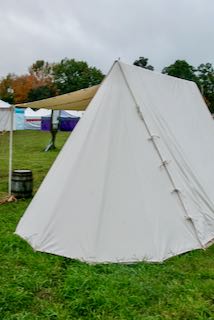 Back of a white canvas tent with a bell