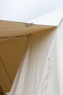 The opening flap of a french bell tent, hung open and high.