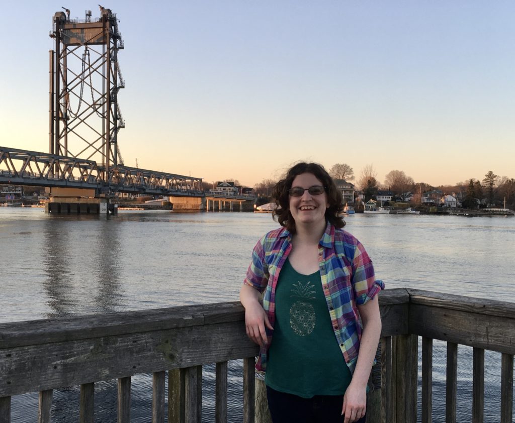 woman on pier with bridge in background