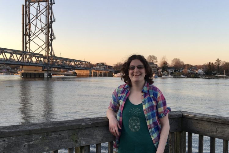 woman on pier with bridge in background