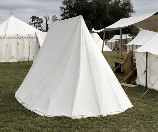 back of a white canvas tent among other white canvas tents