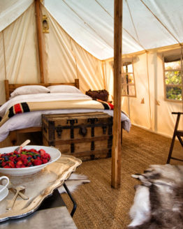 fancy interior of a canvas tent with a double bed.