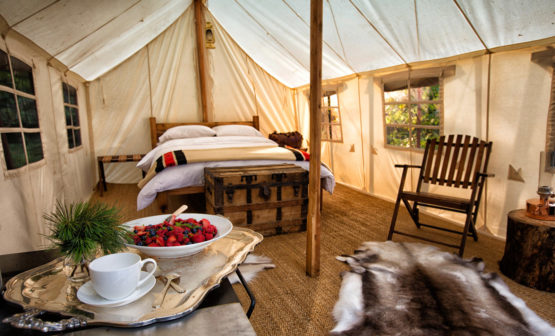 fancy interior of a canvas tent with a double bed.
